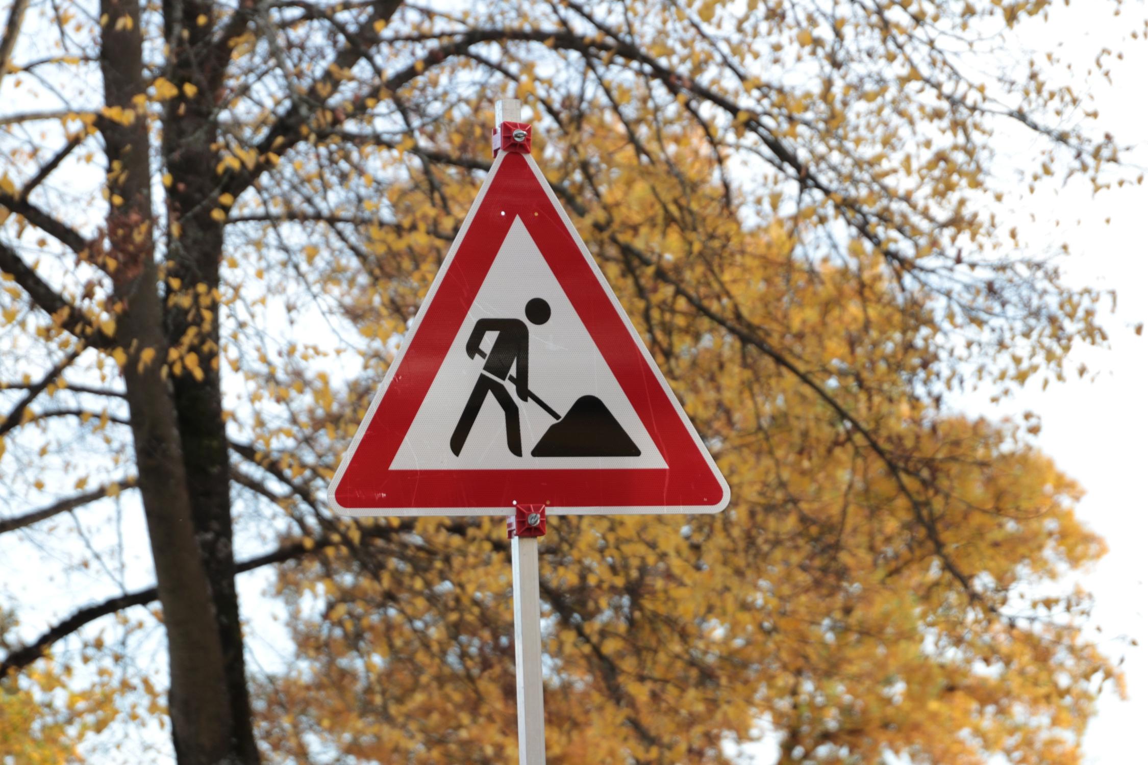 Baustelle Verkehrsschild Baustelle vor herbstlichen Bäumen